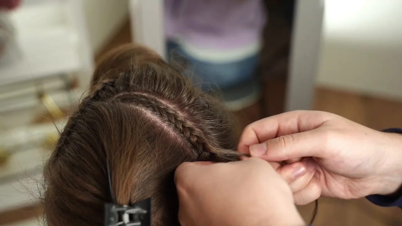 Create several small reverse French braids through the top strip, then continue each length as a regular braid.