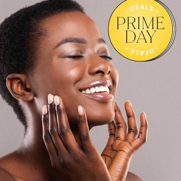 Smiling person enjoying Prime Day deals on a gray background