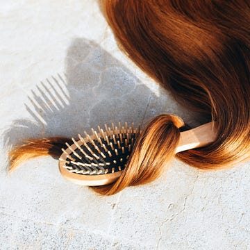 Hairbrush entwined with a strand of hair.